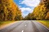 stock-photo-asphalt-road-in-autumn-forest-and-blue-sky-247102150