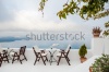 stock-photo-cafe-on-the-terrace-with-a-beautiful-sea-view-foggy-morning-white-architecture-on-santorini-227087314