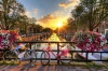 stock-photo-beautiful-sunrise-over-amsterdam-the-netherlands-with-flowers-and-bicycles-on-the-bridge-in-spr
