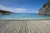 stock-photo-empty-wooden-jetty-on-the-seashore-with-idyllic-view-in-the-background-158082497