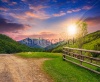 stock-photo-unreal-summer-landscape-fence-near-the-meadow-crossroad-path-on-the-hillside-composi